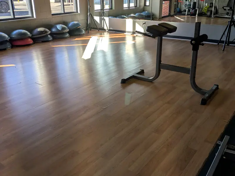 Gym floor with exercise balls and a bench after a commercial clean