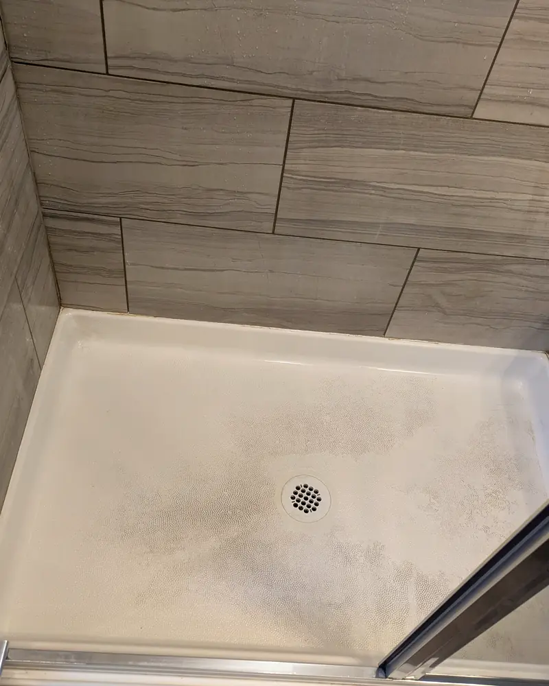 The same shower pan white and clean after a deep clean